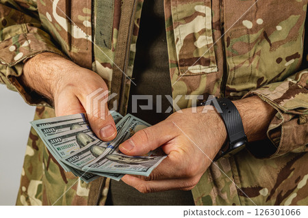 Military personnel counts cash in a tactical outfit 126301066