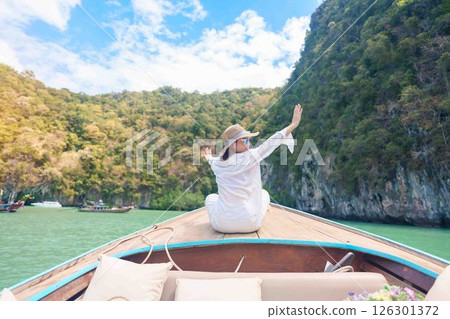 Happy Woman tourist in private longtail boat trip to koh Hong lagoon island at Krabi, Thailand. landmark, tropical destination, southeast Asia Travel, summer vacation, wanderlust and holiday concept Happy Woman tourist in private longtail boat trip to koh Hong lagoon island at Krabi, Thailand. landmark, tropical destination, southeast Asia Travel, summer vacation, wanderlust and holiday concept 126301372
