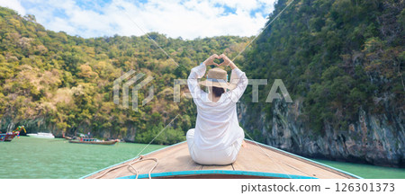 Happy Woman tourist in private longtail boat trip to koh Hong lagoon island at Krabi, Thailand. landmark, tropical destination, southeast Asia Travel, summer vacation, wanderlust and holiday concept 126301373