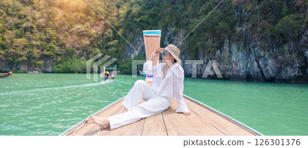 Happy Woman tourist in private longtail boat trip to koh Hong lagoon island at Krabi, Thailand. landmark, tropical destination, southeast Asia Travel, summer vacation, wanderlust and holiday concept 126301376