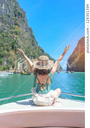Woman tourist on boat trip, happy traveller relaxing at Pileh lagoon on Phi Phi island, Krabi, Thailand. Exotic landmark, destination Southeast Asia Travel, summer vacation and holiday concept Woman tourist on boat trip, happy traveller relaxing at Pileh lagoon on Phi Phi island, Krabi, Thailand. Exotic landmark, destination Southeast Asia Travel, summer vacation and holiday concept 126301394