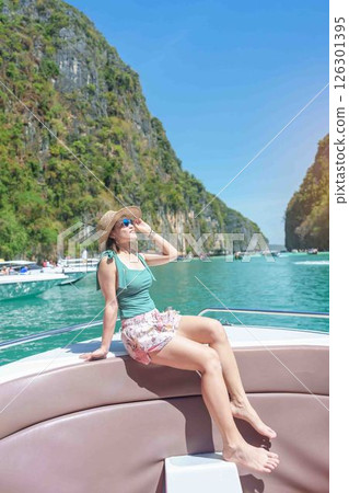 Woman tourist on boat trip, happy traveller relaxing at Pileh lagoon on Phi Phi island, Krabi, Thailand. Exotic landmark, destination Southeast Asia Travel, summer vacation and holiday concept 126301395