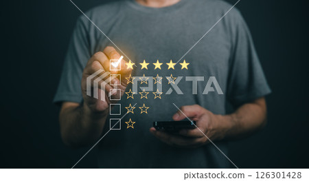 Close-up businessman hand Using Mobile Device to Rate Experience with Star Ratings on Dark Background, Customer Feedback Concept, Evaluation and Review Process Close-up businessman hand Using Mobile Device to Rate Experience with Star Ratings on Dark Background, Customer Feedback Concept, Evaluation and Review Process 126301428