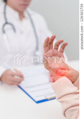 Elderly Patient Woman wrist pain and Consulting doctor. muscle ache from Carpal Tunnel Syndrome, De Quervain s tenosynovitis, rheumatoid, arthritis, gout, Parkinson disease and ergonomic healthcare 126301739