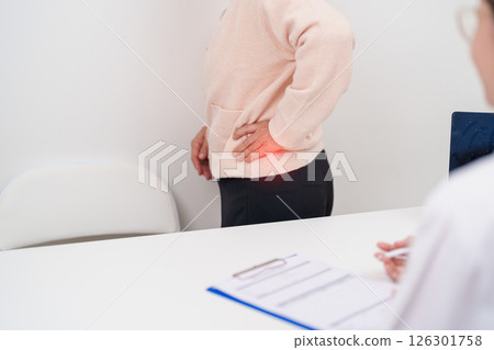 Elderly woman having back body ache and consulting doctor in hospital. Senior female with muscle pain due to Piriformis Syndrome, Low Back Pain and Spinal Compression. Office syndrome and medical Elderly woman having back body ache and consulting doctor in hospital. Senior female with muscle pain due to Piriformis Syndrome, Low Back Pain and Spinal Compression. Office syndrome and medical 126301758