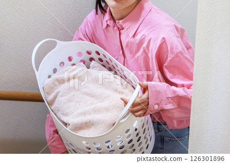 A young lady with a laundry basket A young lady with a laundry basket 126301896