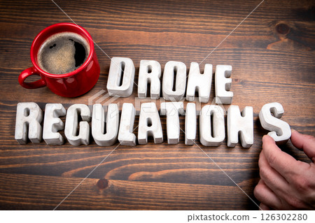 Drone Regulations. Concrete alphabet letters and coffee mug on dark wooden texture background 126302280