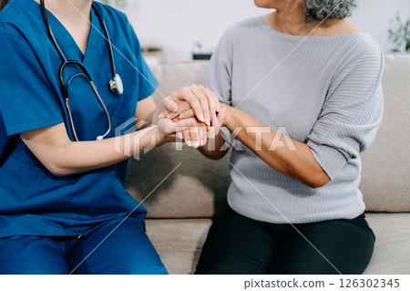 Young Caregiver doctor examine older patient use blood pressure gauge. woman therapist nurse at nursing home taking care of senior elderly woman sit on sofa. 126302345