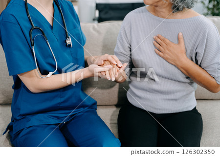 Young Caregiver doctor examine older patient use blood pressure gauge. woman therapist nurse at nursing home taking care of senior elderly woman sit on sofa. Young Caregiver doctor examine older patient use blood pressure gauge. woman therapist nurse at nursing home taking care of senior elderly woman sit on sofa. 126302350