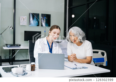 Portrait of female doctor explaining diagnosis to her patient. Doctor Meeting With Patient In Exam Room. A medical practitioner reassuring a patient Portrait of female doctor explaining diagnosis to her patient. Doctor Meeting With Patient In Exam Room. A medical practitioner reassuring a patient 126302399