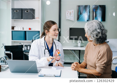Portrait of female doctor explaining diagnosis to her patient. Doctor Meeting With Patient In Exam Room. A medical practitioner reassuring a patient in hospital 126302429