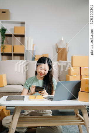 Startup small business SME, Entrepreneur owner woman using smartphone or tablet taking receive and checking online purchase shopping orde Startup small business SME, Entrepreneur owner woman using smartphone or tablet taking receive and checking online purchase shopping orde 126303362