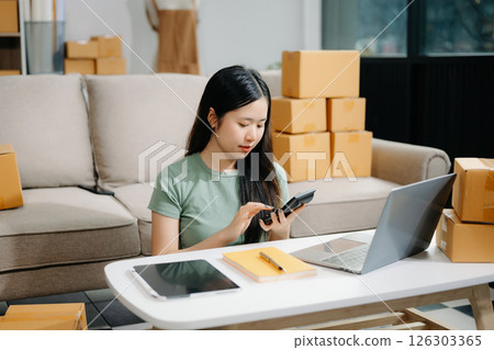 Startup small business SME, Entrepreneur owner woman using smartphone or tablet taking receive and checking online purchase shopping orde Startup small business SME, Entrepreneur owner woman using smartphone or tablet taking receive and checking online purchase shopping orde 126303365