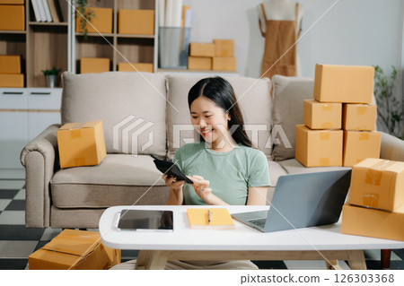 Startup small business SME, Entrepreneur owner woman using smartphone or tablet taking receive and checking online purchase shopping orde Startup small business SME, Entrepreneur owner woman using smartphone or tablet taking receive and checking online purchase shopping orde 126303368