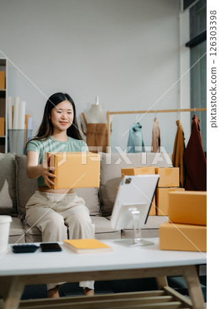 Asian lady blogger showing clothes in front of the camera to recording vlog video live streaming Asian lady blogger showing clothes in front of the camera to recording vlog video live streaming 126303398