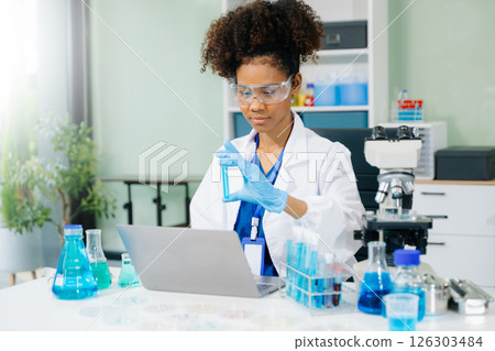 female scientist working with micro pipettes analyzing biochemical samples, advanced science chemical laboratory 126303484