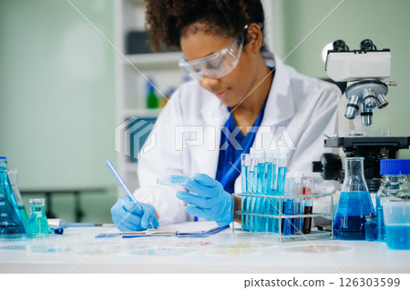 female scientist working with micro pipettes analyzing biochemical samples, advanced science chemical laboratory 126303599