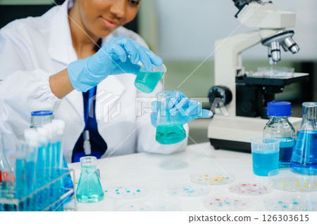 Young scientists conducting research investigations in a medical laboratory, a researcher in the foreground 126303615