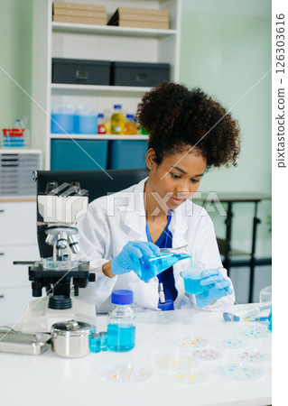 Young scientists conducting research investigations in a medical laboratory, a researcher in the foreground 126303616