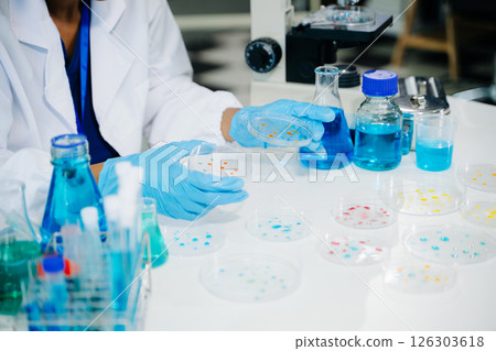 Young scientists conducting research investigations in a medical laboratory, a researcher in the foreground 126303618