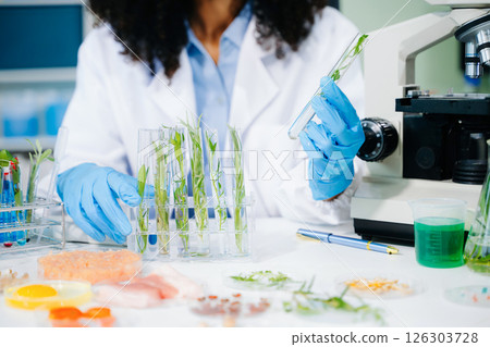 Food scientist in a lab testing food samples with modern equipment, ensuring food safety and quality control. Food scientist in a lab testing food samples with modern equipment, ensuring food safety and quality control. 126303728
