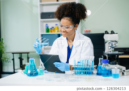 female scientist working with micro pipettes analyzing biochemical samples, advanced science chemical laboratory 126304213