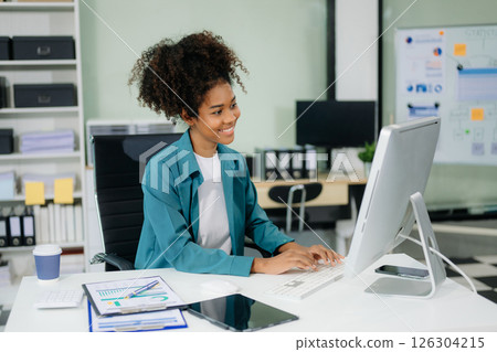 Young beautiful woman using laptop and tablet while sitting at her working place. 126304215