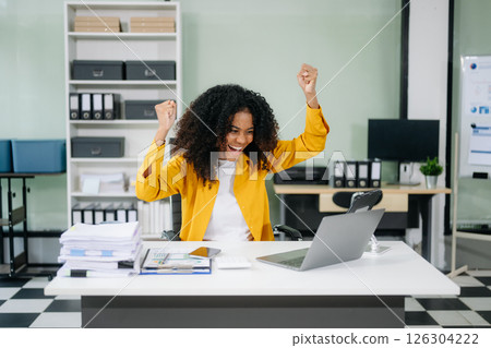 Young businesswoman working with working notepad, tablet and laptop documents talking on the smartphone, tablet Young businesswoman working with working notepad, tablet and laptop documents talking on the smartphone, tablet 126304222