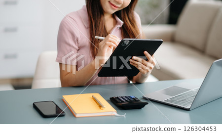 Confident businesswoman working on laptop,tablet and smartphone at her workplace at office. 126304453
