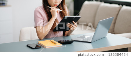 Confident businesswoman working on laptop,tablet and smartphone at her workplace at office. 126304454
