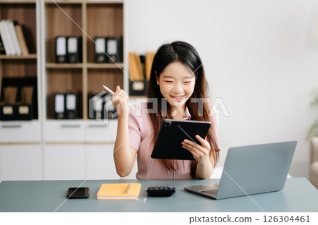 Asian woman sitting at a desk using a laptop computer Navigating Finance and Marketing with Technology Asian woman sitting at a desk using a laptop computer Navigating Finance and Marketing with Technology 126304461