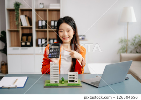 Real estate broker agent presenting and consult to customer to decision making sign insurance form agreement, home model, concerning mortgage loan offer 126304656