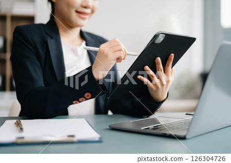 Confident businessman working on laptop,tablet and smartphone at her workplace at office. 126304726
