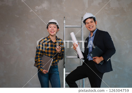 Successful engineer teams working together wear worker helmets hardhat on construction site. Successful engineer teams working together wear worker helmets hardhat on construction site. 126304759