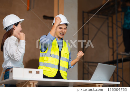 Successful engineer teams working together wear worker helmets hardhat on construction site. Successful engineer teams working together wear worker helmets hardhat on construction site. 126304763