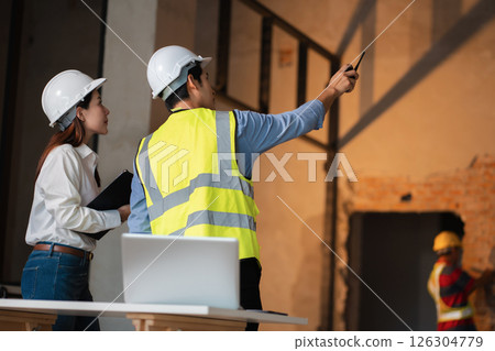 civil engineer and worker discussing issues at the construction site. 126304779