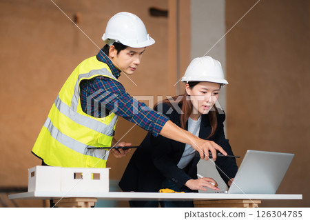 Engineering Team Collaborates on Blueprint Model in Corporate Office. 126304785