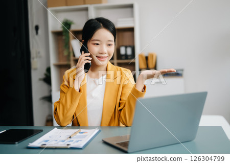 Businesswoman Analyzing Finance on Tablet and Laptop at modern Office Desk tax, report, accounting, statistics, and analytical research concept 126304799