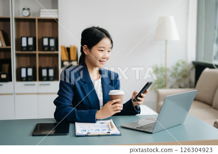 Businesswoman Analyzing Finance on Tablet and Laptop at modern Office Desk tax, report, accounting, statistics, and analytical research concept Businesswoman Analyzing Finance on Tablet and Laptop at modern Office Desk tax, report, accounting, statistics, and analytical research concept 126304923