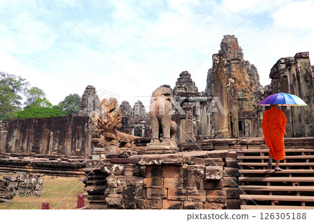 Buddhist monk in Prasat Bayon Temple, famous landmark Angkor Wat, Siem Reap. Topic of tours, travel, trip abroad on vacation. Complex is a prominent symbol of Cambodia and a key tourist attraction 126305188