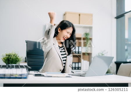 Asian business woman are delighted and happy with the work they do on their tablet, laptop 126305211