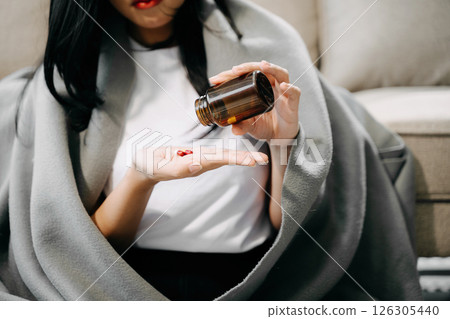 woman holding bottle with pills on hand going to take medicaments prescribed woman holding bottle with pills on hand going to take medicaments prescribed 126305440