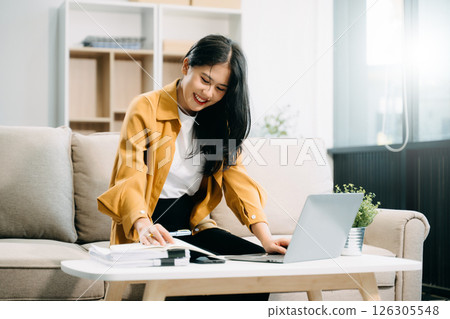 Young asian woman relax on comfortable couch at home texting messaging on smartphone and tablet smiling girl use cellphone 126305548