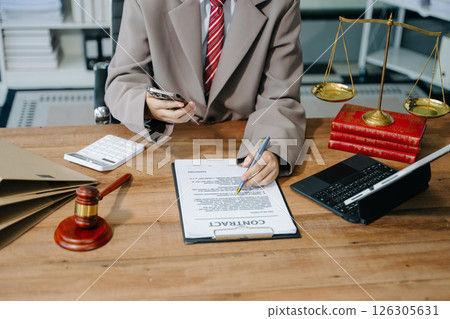 justice and law concept. Male judge in a courtroom the gavel, working with smart phone and laptop and digital tablet 126305631