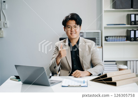 Young business man working at office with laptop, tablet and taking notes on the paper. 126305758