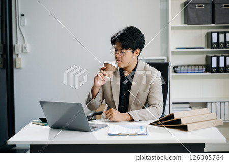 Young business man working at office with laptop, tablet and taking notes on the paper. 126305784