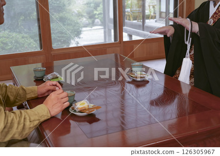 A temple parishioner talking with the head priest A temple parishioner talking with the head priest 126305967