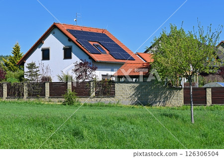 Family house with solar panels on the roof. Home photovoltaic power plant. Concept for industry and green cheaper electricity from renewable sources. 126306504