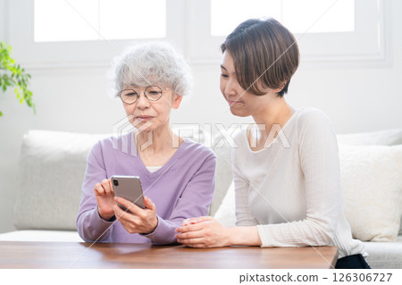 資深女性向年輕女性學習如何操作智慧型手機 資深女性向年輕女性學習如何操作智慧型手機 126306727