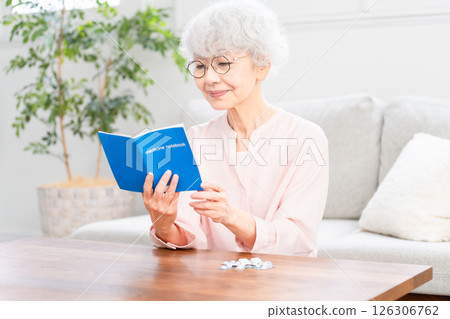 檢查她的醫學筆記本的高級婦女 126306762